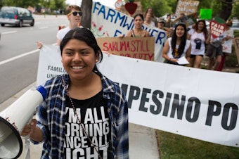 caption: Alicia Santos, 17, leads marchers in a protest targeting Sakuma Brothers Farm.