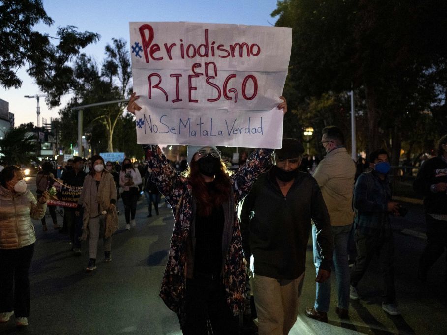 caption: Journalists and supporters hold signs as they protest the murders of their colleagues Lourdes Maldonado and Margarito Martinez in Tijuana, Baja California, Mexico. The sign says, "Journalism at risk. Don't kill the truth."
