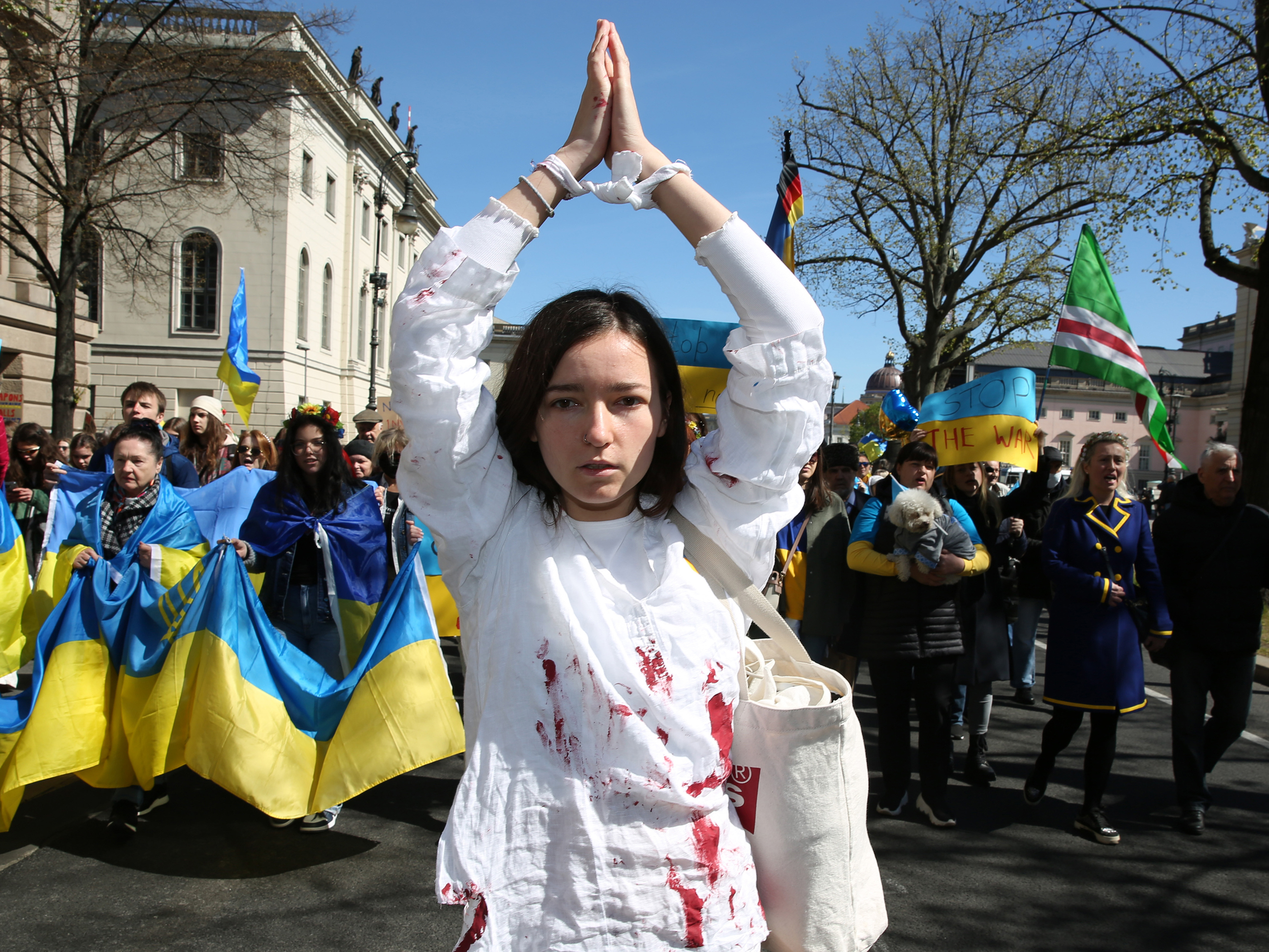 caption: A woman representing a rape victim leads protesters in Berlin demonstrating in an April 16 march against Russian military aggression in the ongoing wars in Ukraine and Syria.
