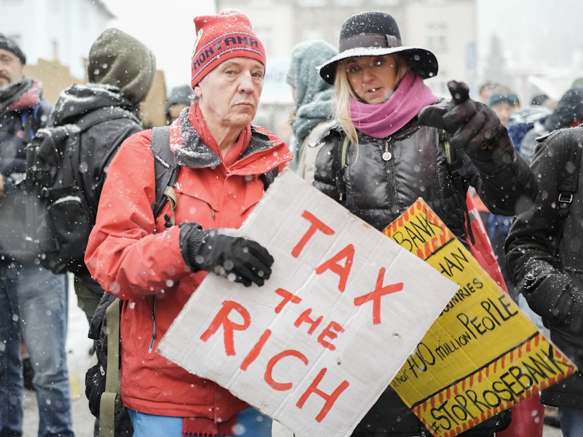 caption: A demonstration at the annual meeting of the World Economic Forum in Davos, Switzerland, in 2023. A perennial Davos topic is how to improve the lives of the world's poor.