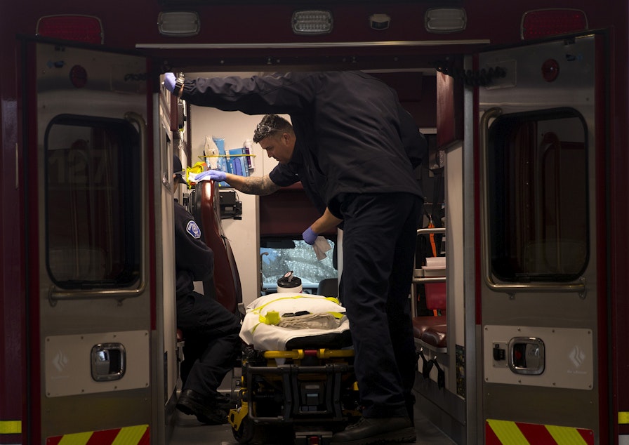 caption: Members of the Kirkland Fire Department disinfect the interior of an ambulance after a patient was transported from the Life Care Center of Kirkland on Monday, March 2, 2020, at Evergreen Health Medical Center in Kirkland. 