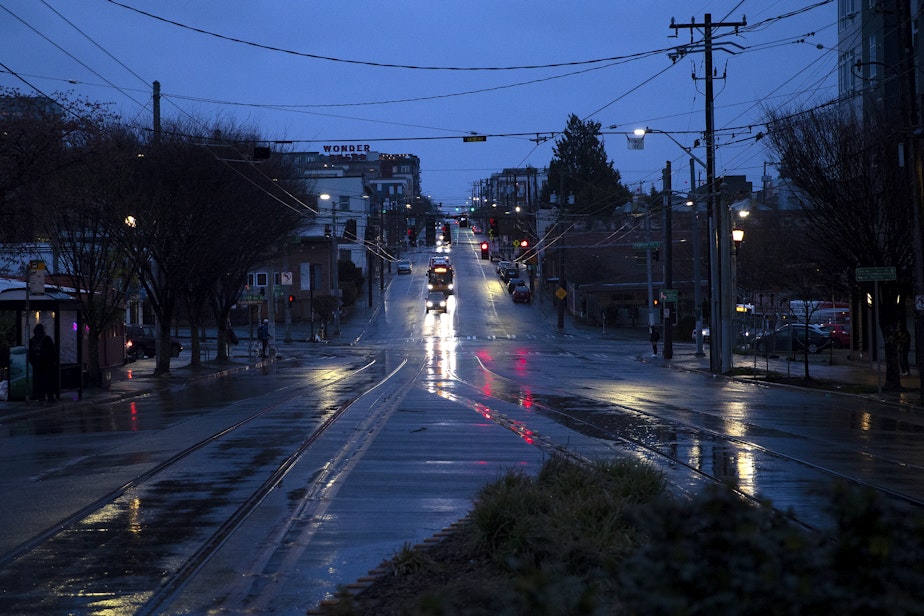 caption: The sun sets on the Little Saigon neighborhood on Thursday, March 20, 2025, in Seattle.