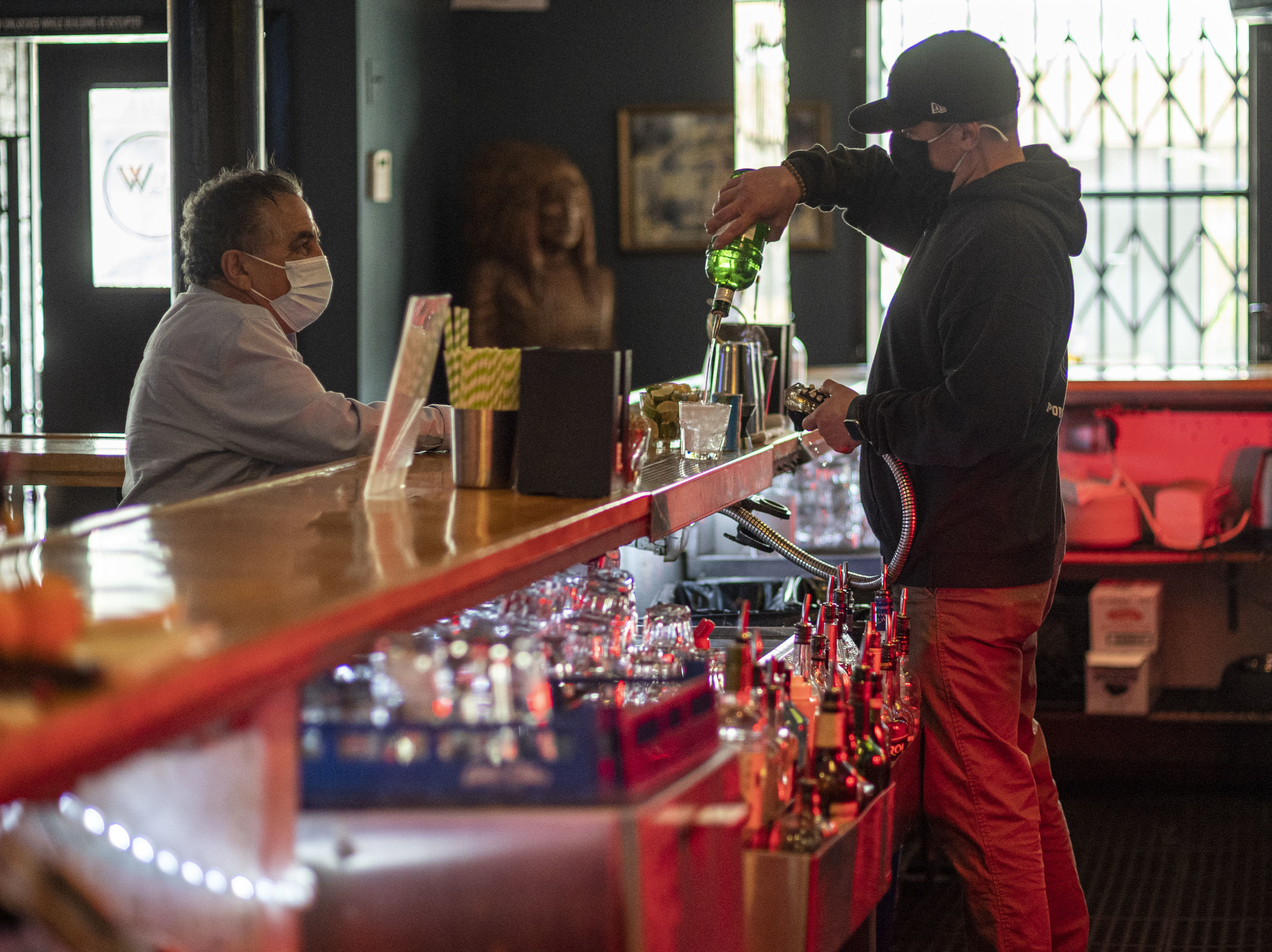 caption: A bartender wearing a protective mask mixes a drink inside a bar in San Francisco on May 6. The latest retail sales data out on Friday showed an increase in sales at restaurants at bars as more people are venturing out amid the continued reopening of the U.S. economy.