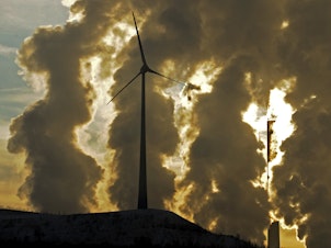 caption: A wind turbine in front of a steaming coal power plant in Gelsenkirchen, Germany in 2010. New reports find countries' latest promises to cut climate emissions are still not enough to avoid the worst impacts from warming.