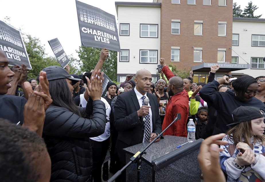 caption: People cheer as attorney James Bible, center, speaks at a memorial outside where a pregnant mother was shot and killed Sunday by police on June 20, 2017 in Seattle.
