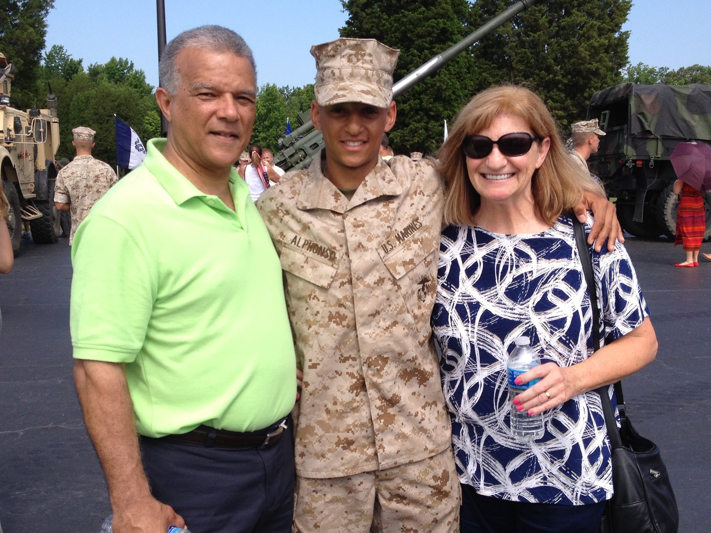 caption: Marine Capt. Cristian Alphonso, center, pictured with his parents, Bonny, left, and Karen, right, in 2014. Alphonso was unable to visit his parents before an upcoming deployment because of Defense Dept. travel restrictions.