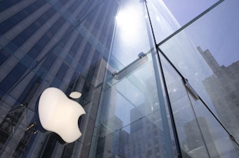caption: In this June 16, 2020 file photo, the sun is reflected on Apple's Fifth Avenue store in New York.