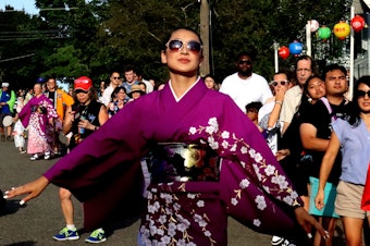 caption: A "dance leader" shows off her moves as the crowd follows along at the Bon Odori festival Saturday in front of the Seattle Betsuin Buddhist Temple.