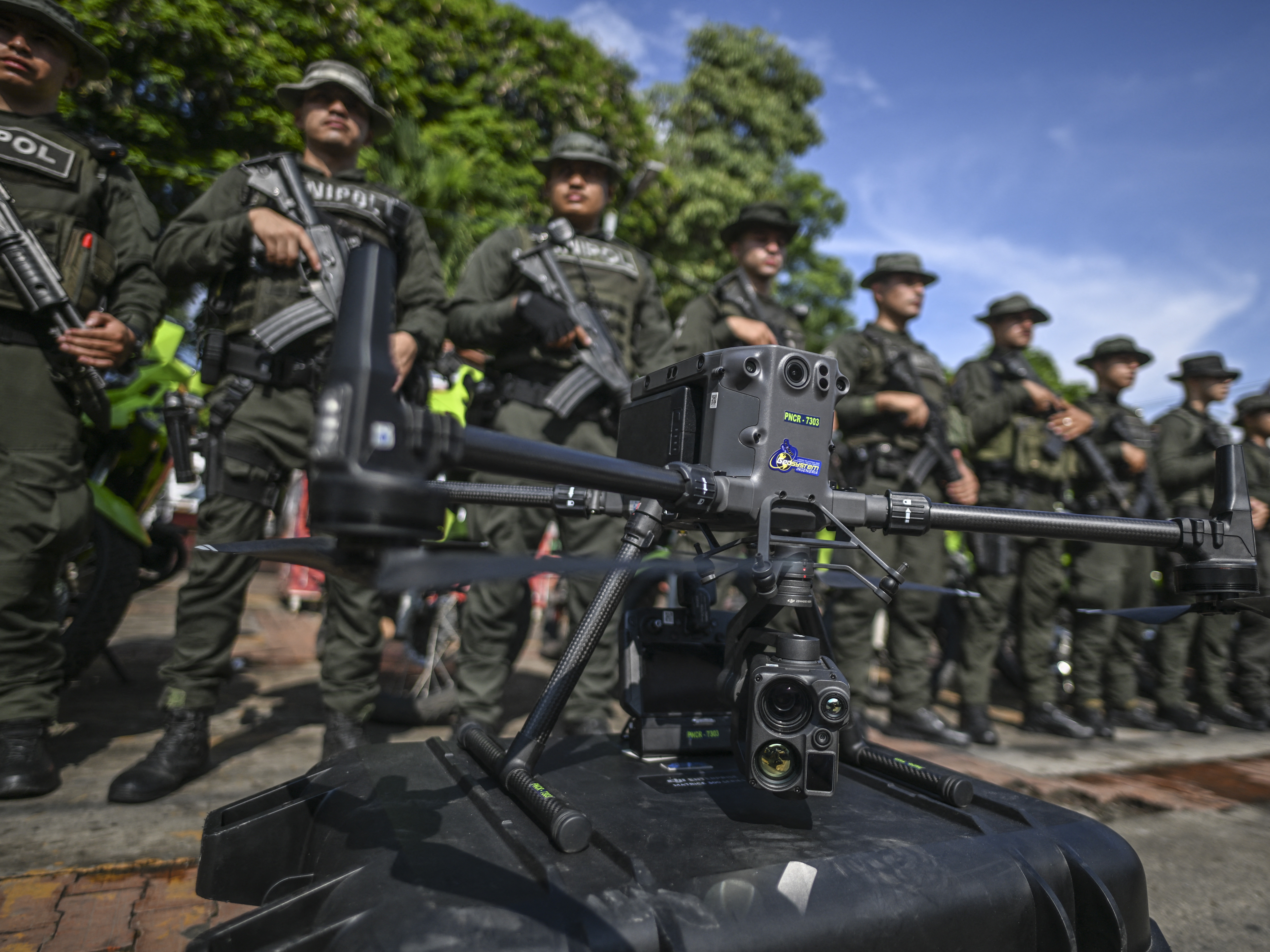 caption: Police officers stand in formation behind a drone that will be used to increase the security in Jamundi, Valle del Cauca province, Colombia, on June 13, 2024.