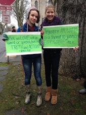 caption: Holy Names students Audrey Long and Theresa Edwards at a December rally outside the Archdiocese of Seattle in support of former Eastside Catholic Vice Principal Mark Zmuda.