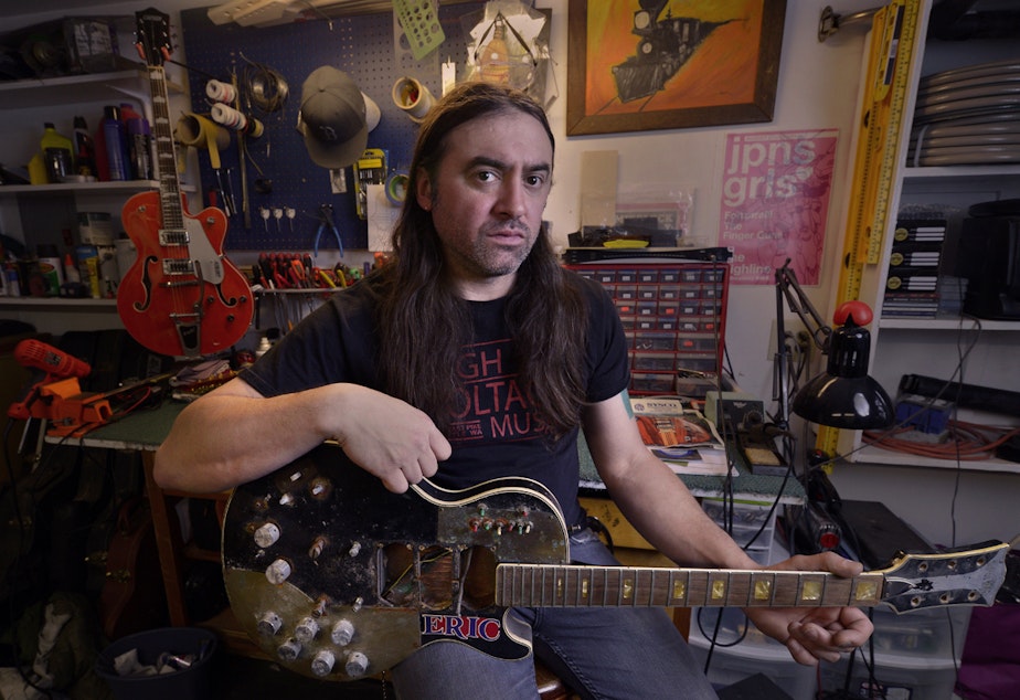 caption: High Voltage Music co-owner Chris Lomba in his backyard shop in north Seattle. He says his shop on Capitol Hill had to close after the loss of a nearby rehearsal space that brought in musicians.