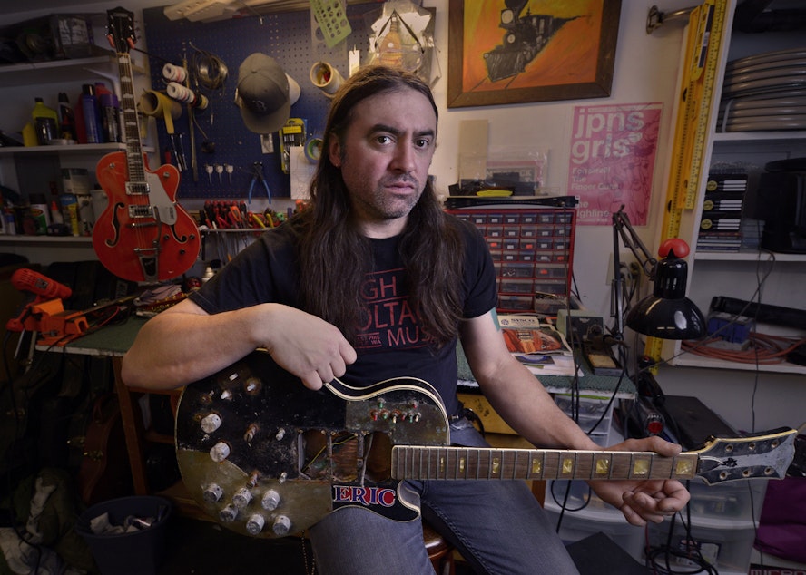 caption: High Voltage Music co-owner Chris Lomba in his backyard shop in north Seattle. He says his shop on Capitol Hill had to close after the loss of a nearby rehearsal space that brought in musicians.