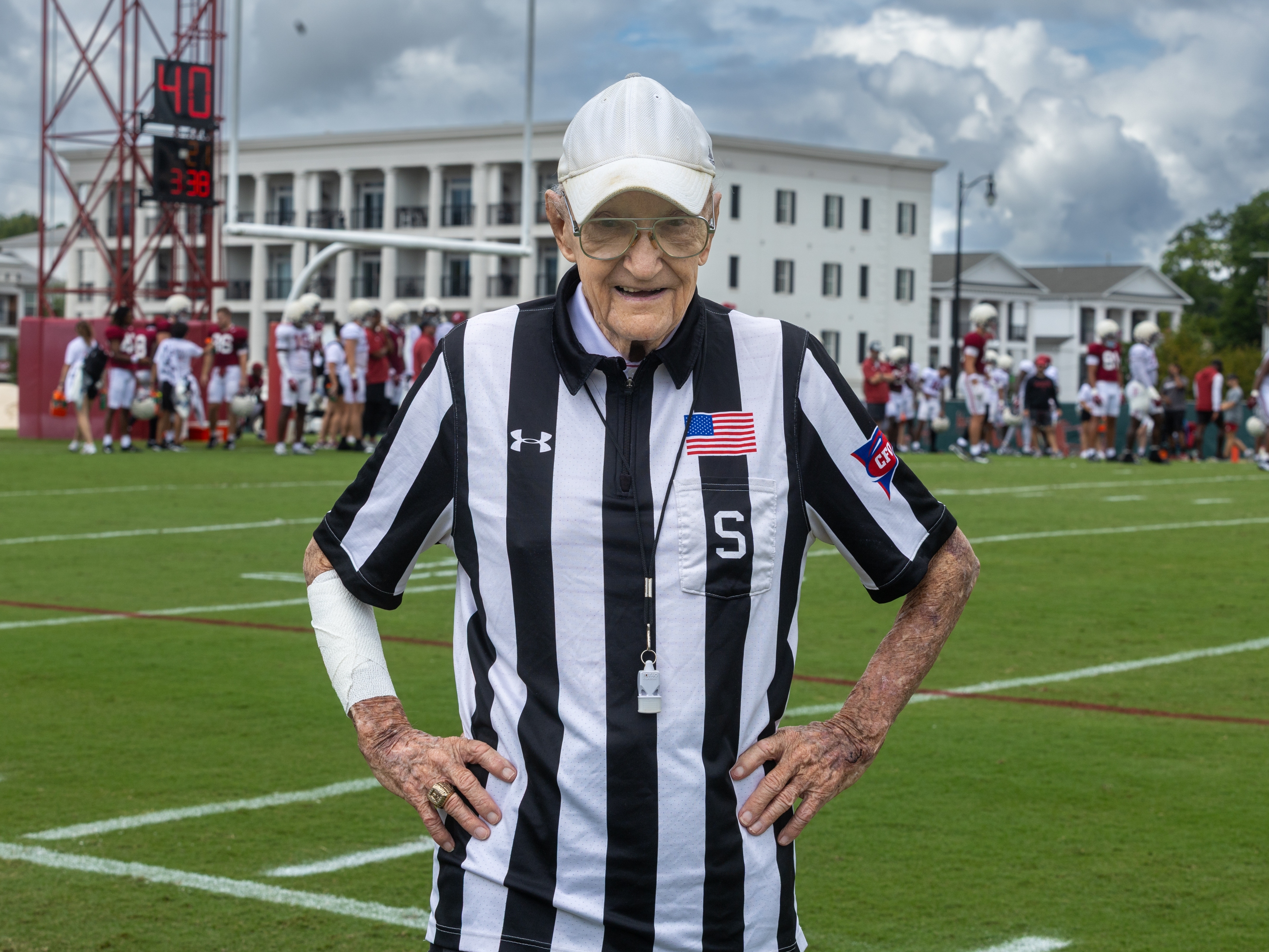 caption: Eddie Conyers stands for a portrait on the University of Alabama football practice field in Tuscaloosa, Ala. Conyers, 97, was a referee for the team during practices for more than 60 years.