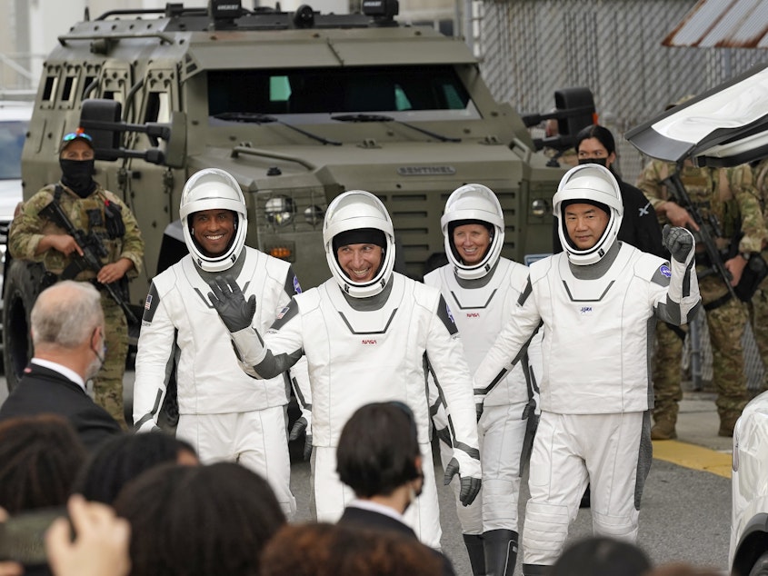 caption: Astronauts, from left, Victor Glover, Michael Hopkins, Shannon Walker, and Japan's Soichi Noguchi wave to family and friends as they leave for the launch site on Sunday.