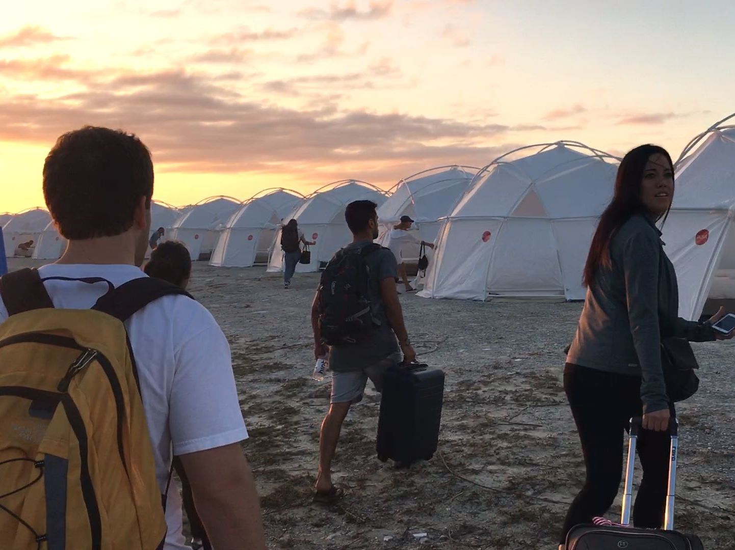 caption: Festival attendees wound up dragging their luggage to tents — and that's only one of the indignities documented in the Netflix film <em>Fyre</em>.