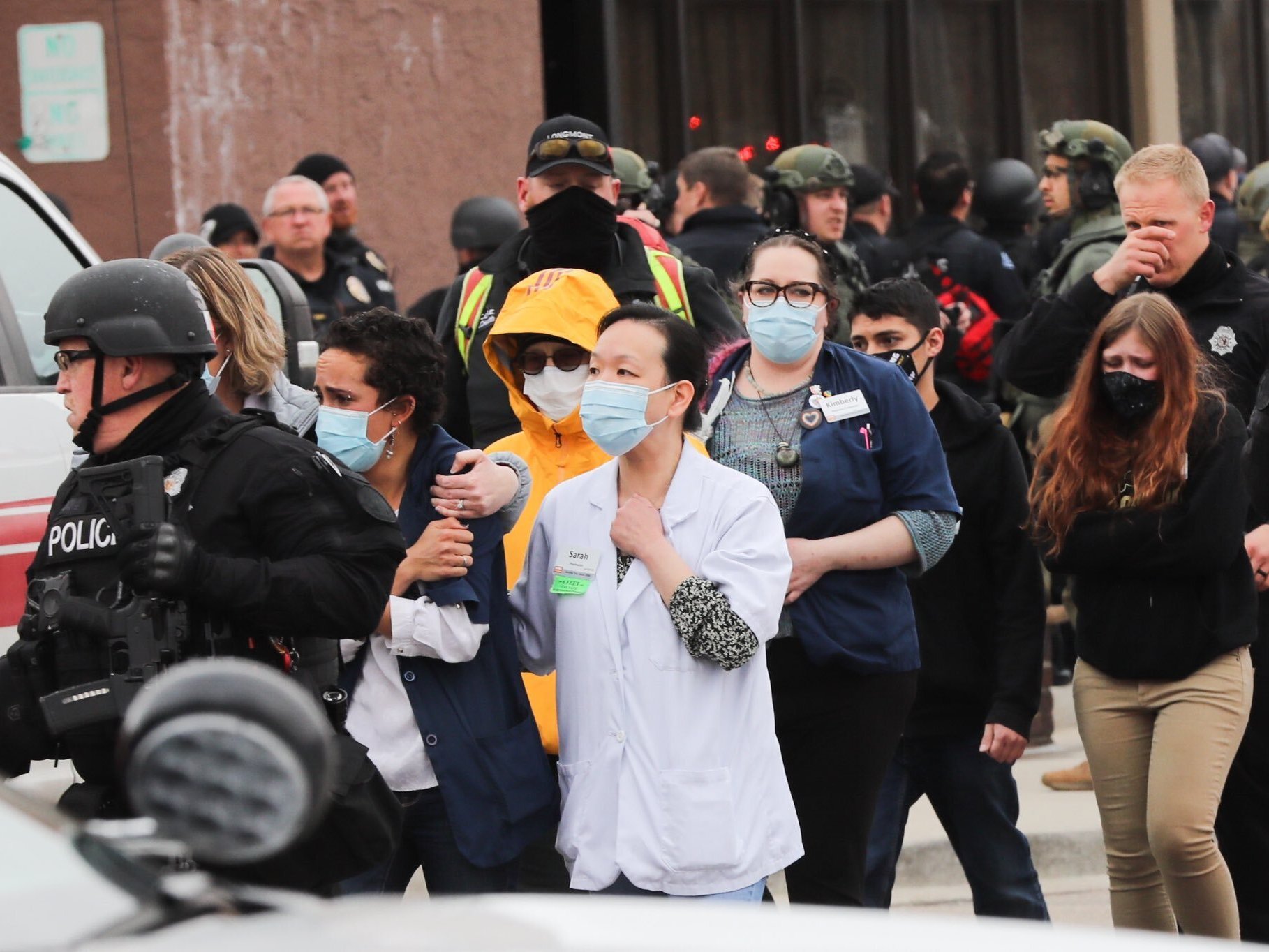 caption: Shoppers who were trapped inside the store during a mass shooting are escorted out.