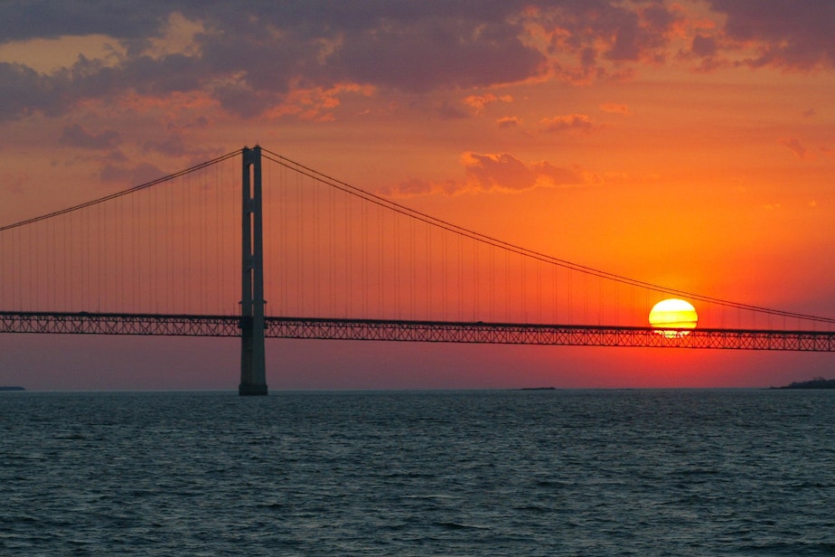 caption: The sun sets over the Mackinac Bridge and the Mackinac Straits as seen from Lake Huron. The bridge is the dividing line between Lake Michigan to the west and Lake Huron to the east. (AP Photo/Al Goldis)