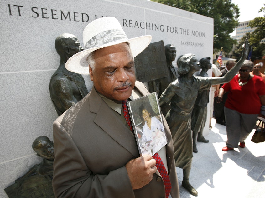 caption: A Maryland sculptor has been chosen to create a statute of civil rights activist Barbara Johns for the U.S. Capitol. In this photo from July 2008, Roderick Johns, brother of civil Barbara Johns, holds a photo of his sister at the newly dedicated Virginia Civil Rights Memorial on the grounds of the State Capitol in Richmond, Va.