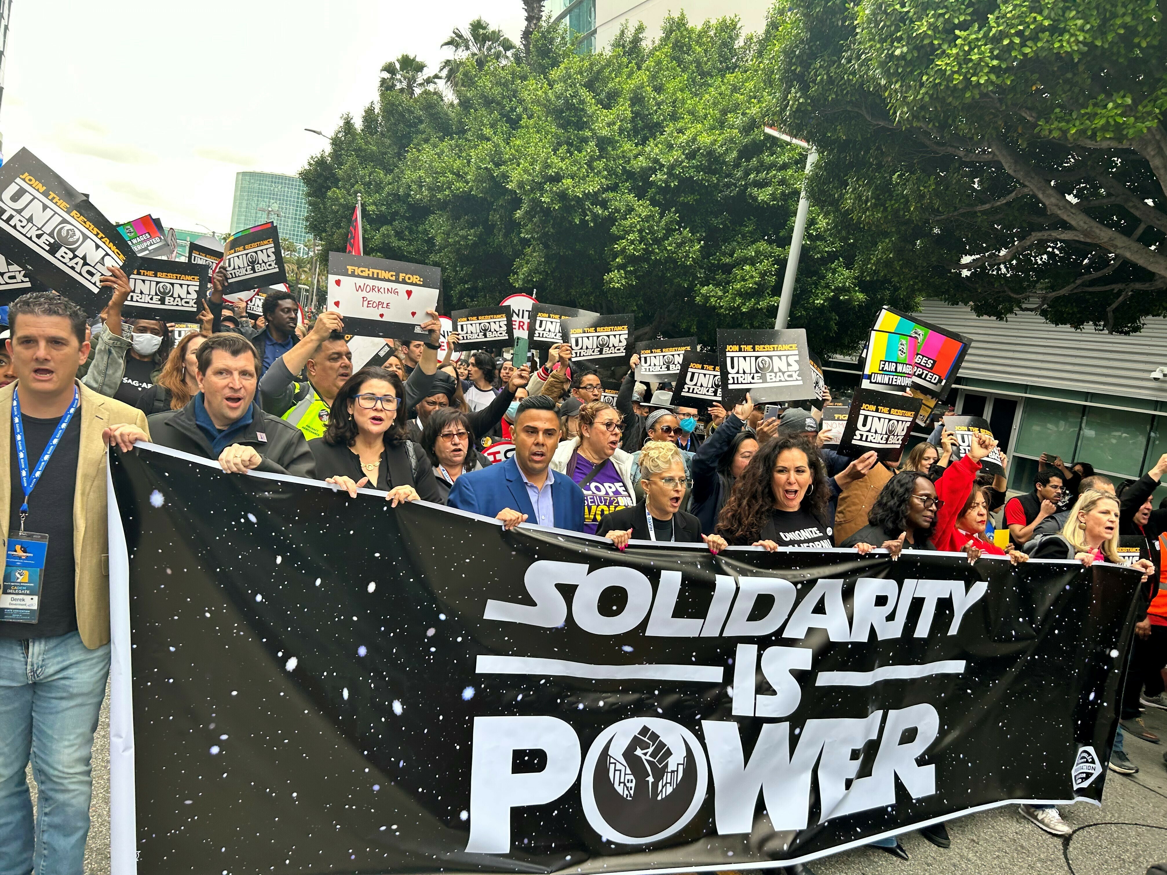 caption: A myriad of workers rallied in downtown Los Angeles in support of striking writers, during an event called "The Unions Strike Back" on May 26, 2023.