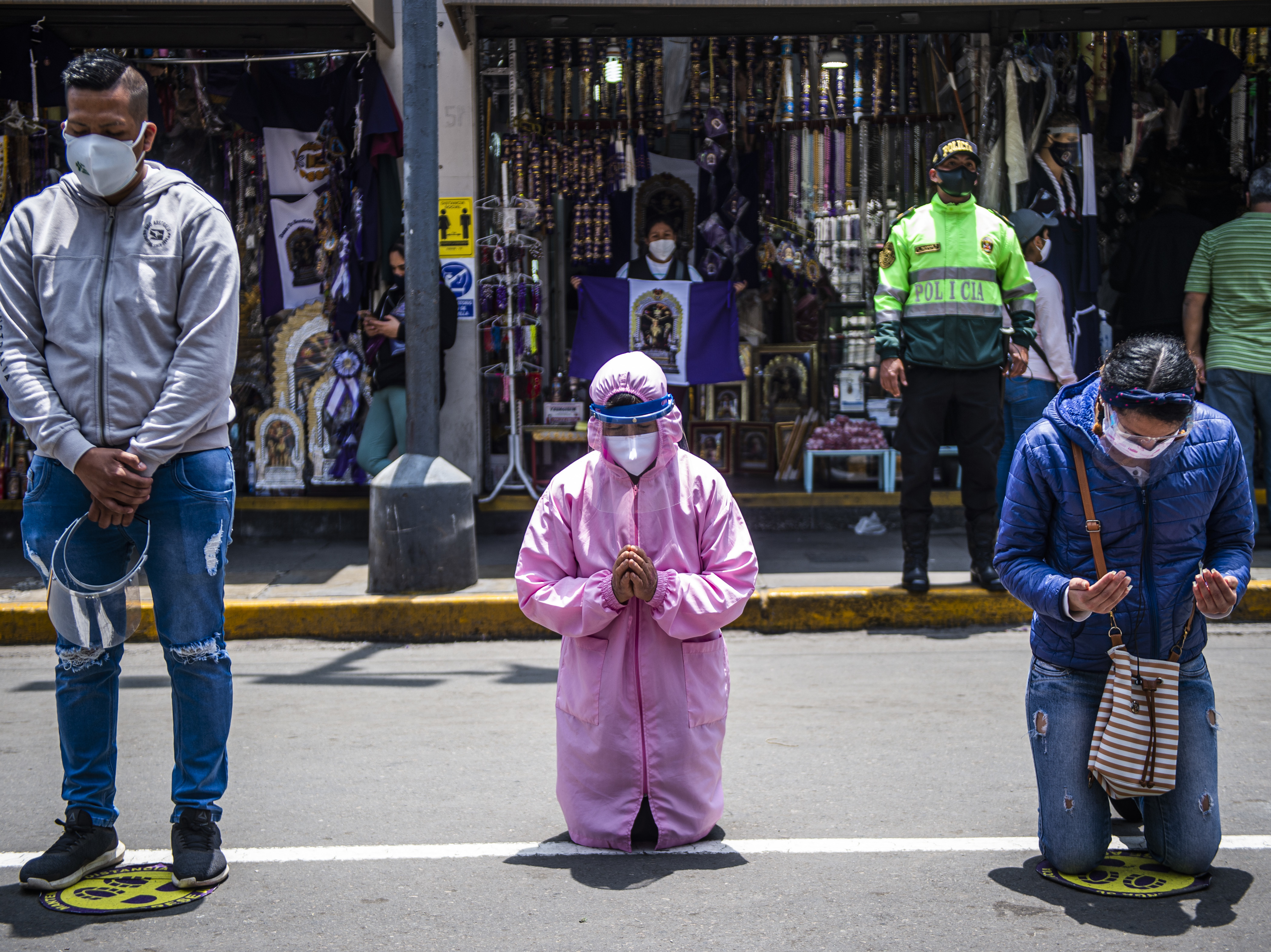 caption: Worshippers pray in the streets of Lima. A government lockdown has shutdown churches as well as businesses to try to stop the spread of the virus.