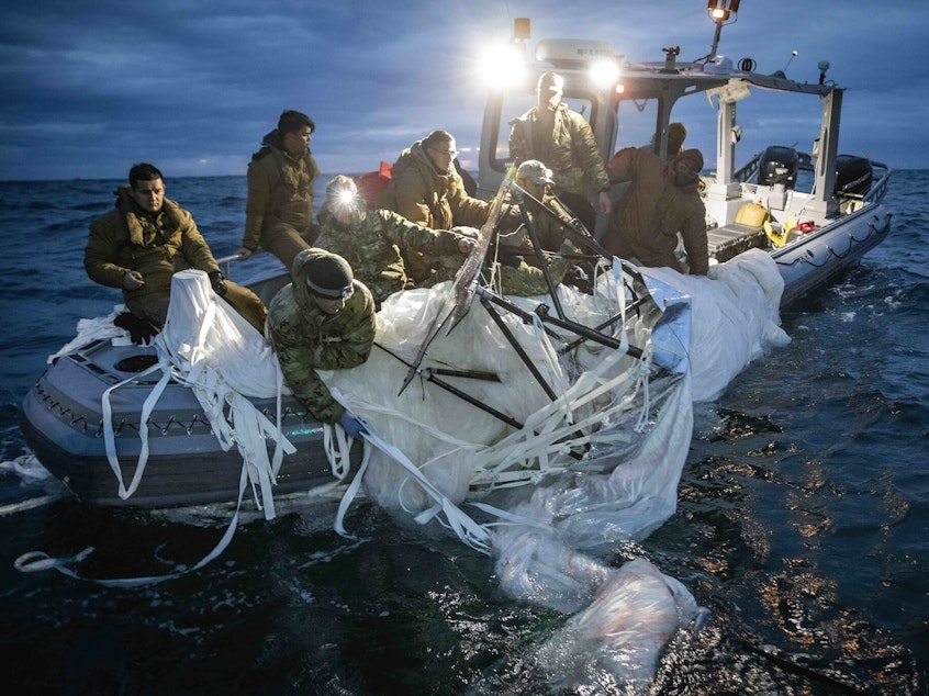 caption: This image provided by the U.S. Navy shows sailors assigned to Explosive Ordnance Disposal Group 2, recovering a high-altitude surveillance balloon off the coast of Myrtle Beach, S.C., on Sunday.