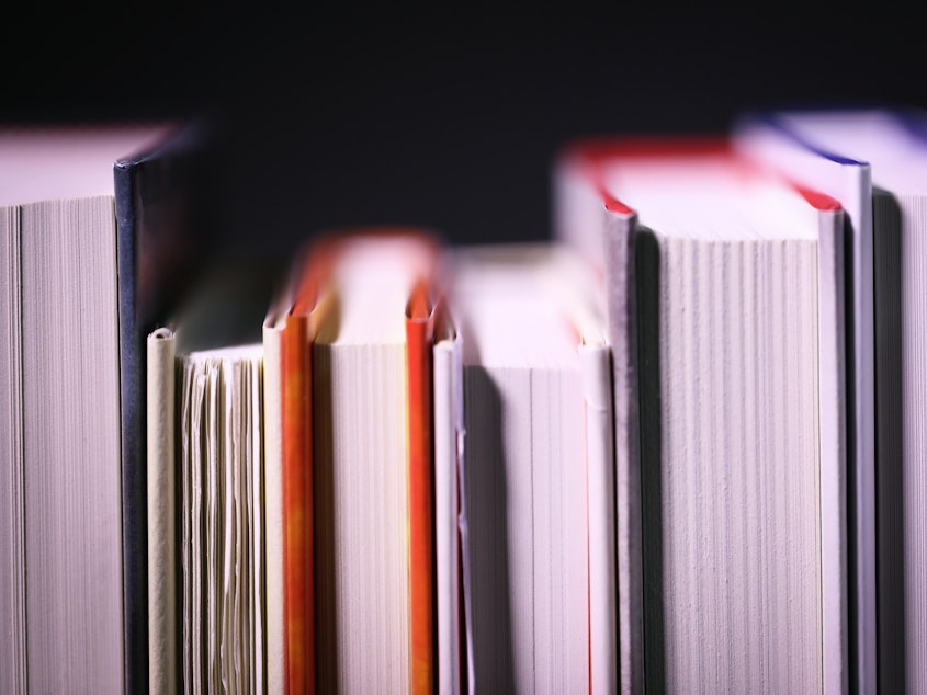 A close-up of a shelf of books, shown from the side of the pages.