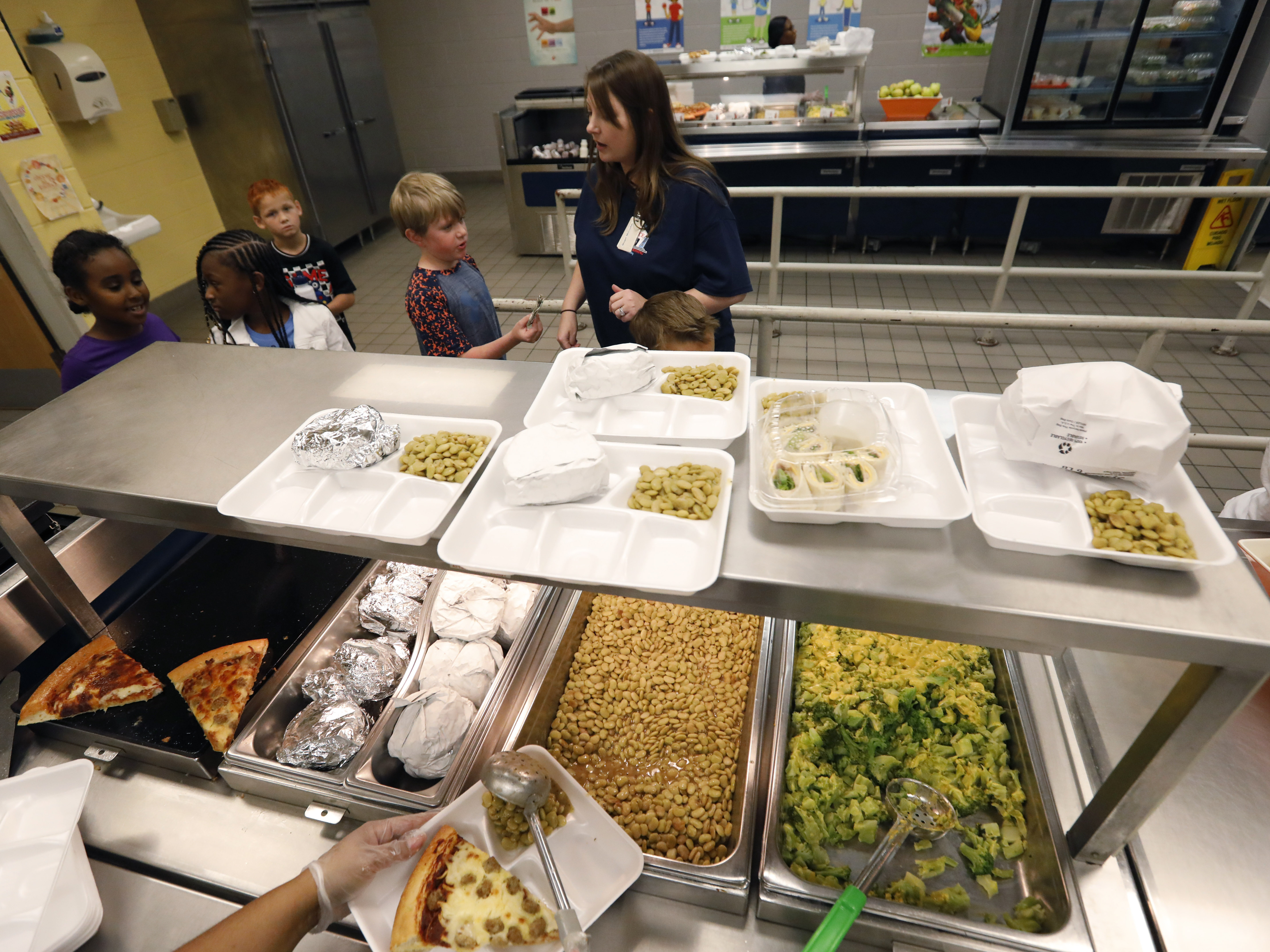 caption: A teacher lines up the students for school-prepared lunches at Madison Crossing Elementary School in Canton, Miss. in 2019. The USDA unveiled new nutrition standards for school meals that would limit sugar and sodium.
