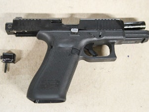 caption: A Glock pistol with an illegal conversion device, sometimes referred to as a Glock switch. The small piece, which is illegal and not manufactured by Glock, can convert a semi-automatic pistol into a fully automatic one.