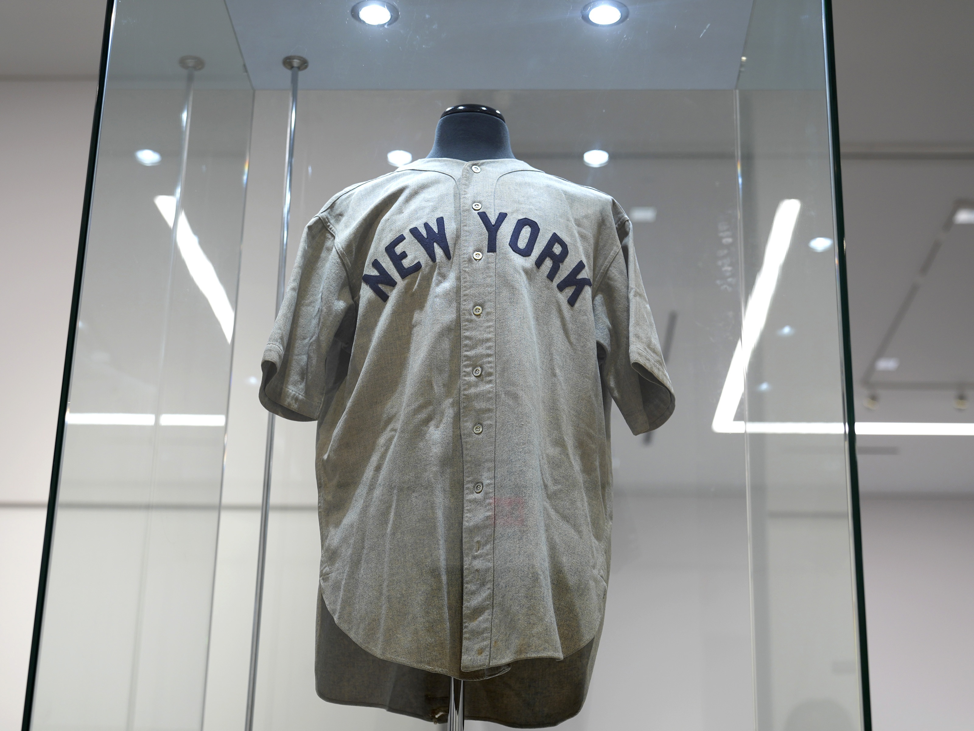 caption: Babe Ruth's New York Yankees jersey, that he's said to have worn in a memorable Game 3 of the 1932 World Series, is displayed at Heritage Auction in Irving, Texas, days before its record sale.