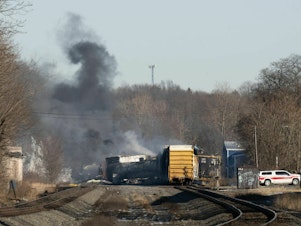 caption: Smoke rises from a derailed cargo train in East Palestine, Ohio, in February of 2023.