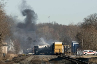 caption: Smoke rises from a derailed cargo train in East Palestine, Ohio, in February of 2023.