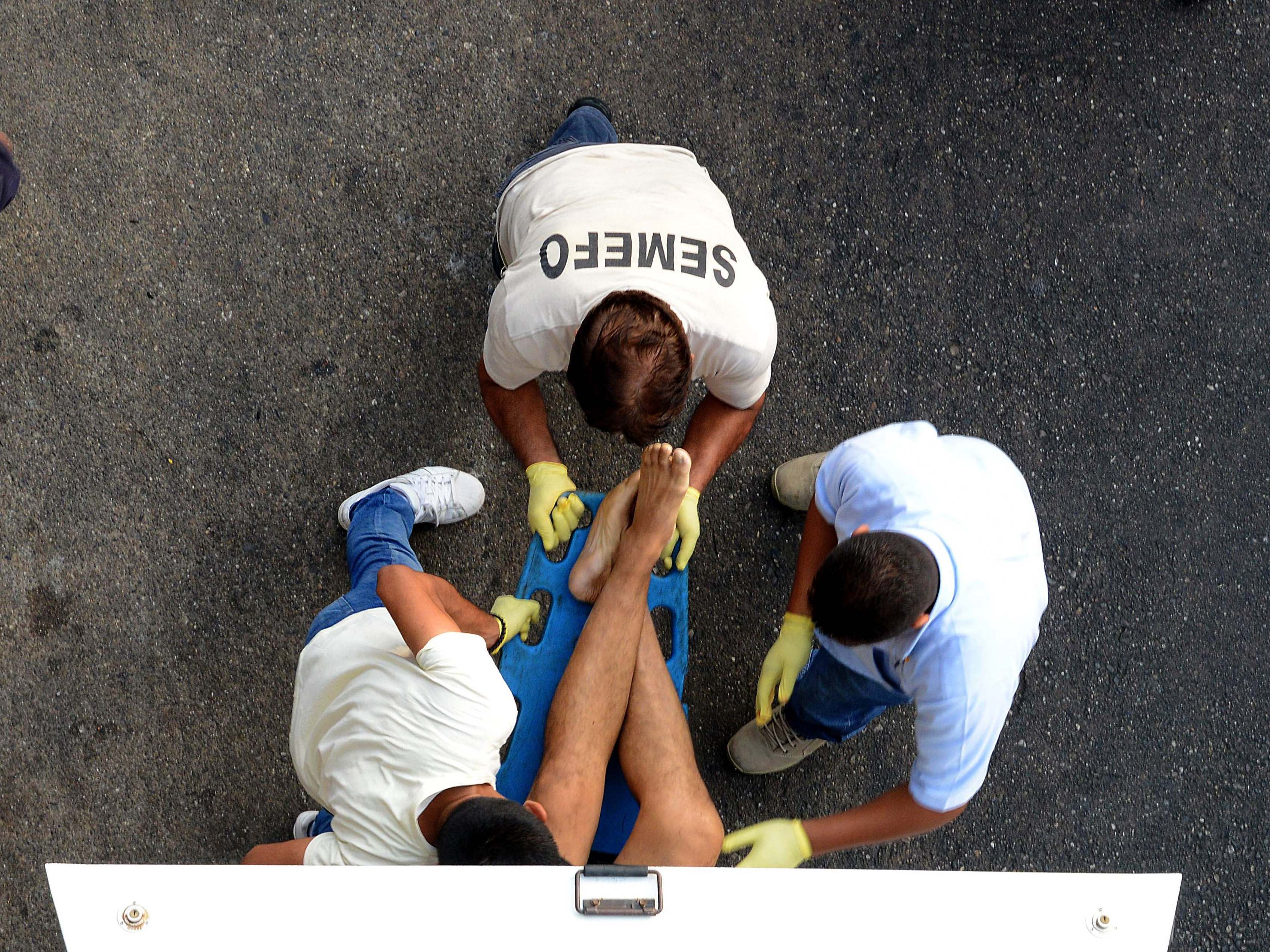 caption: Forensic personnel load the corpse of a man into a van, after he was executed at a shopping mall in Acapulco, Mexico, on April 24, 2018. A new report recorded more than 33,000 homicides in 2018, making it the country's deadliest on record.