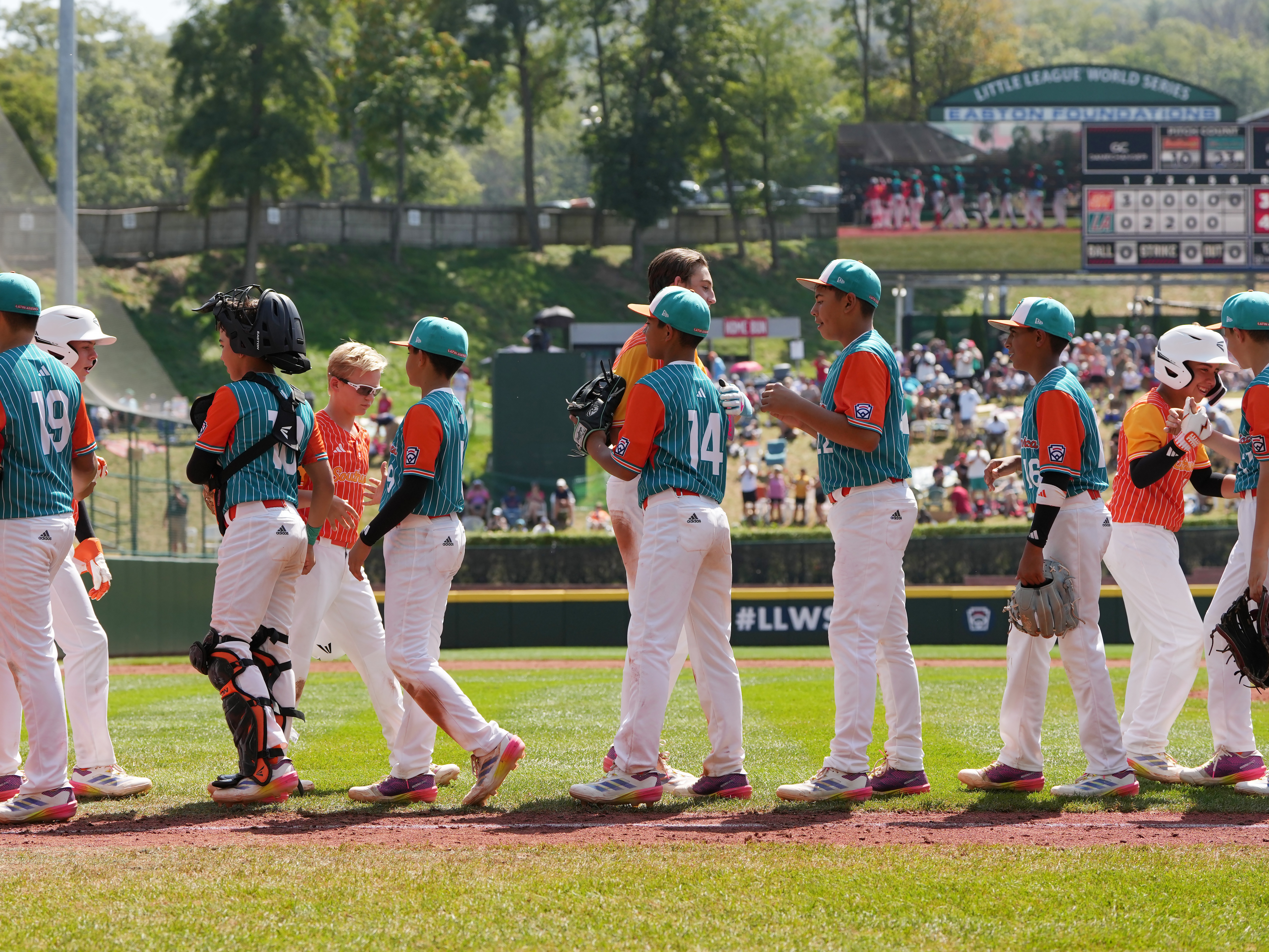 caption: Members of the Southwest Region team from Boerne, Texas and the Latin America Region team from Barquisimeto, Venezuela shake handsafter Latin America won the Little League World Series Consolation Game 4-3 at Howard J. Lamade Stadium on August 25, 2024 in South Williamsport, Pennsylvania.