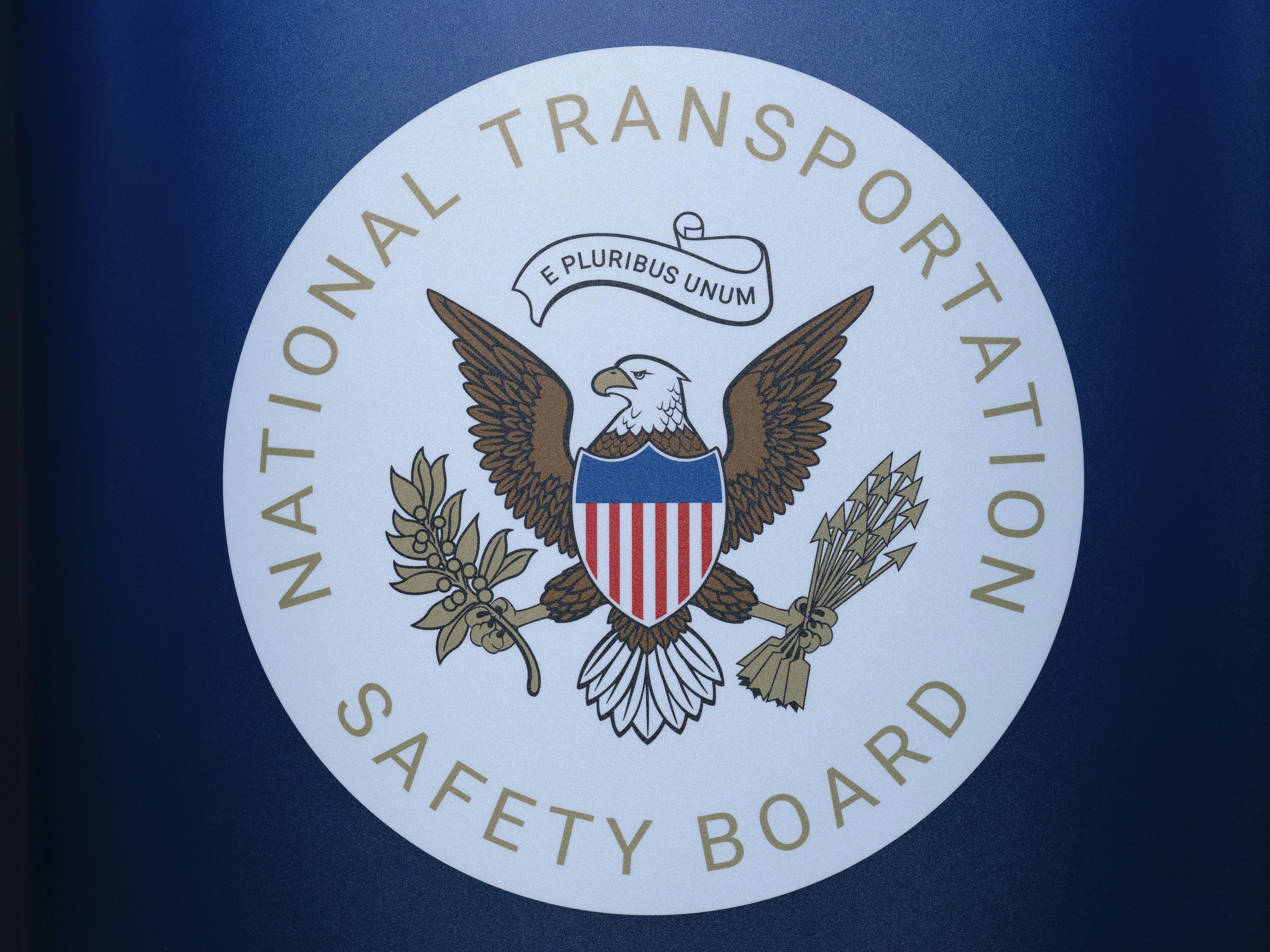 caption: The seal of the National Transportation Safety Board is seen before a news conference at Ronald Reagan Washington National Airport on Jan. 31. The pilot of a small plane that crashed near a North Carolina airport this month had raised a wheel after landing to avoid hitting a turtle on the runway, according to a preliminary report by the NTSB.