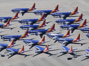 caption: Southwest Airlines Boeing 737 Max aircraft are parked on the tarmac after being grounded, at the Southern California Logistics Airport in Victorville, Calif., on March 28. Boeing said its financial outlook is uncertain as it deals with the 737 Max grounding.