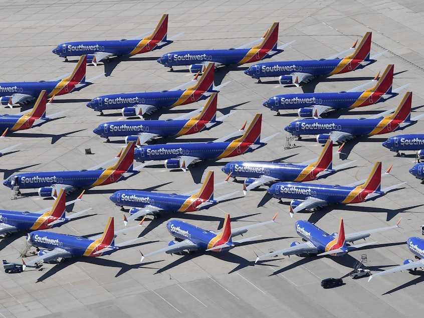 caption: Southwest Airlines Boeing 737 Max aircraft are parked on the tarmac after being grounded, at the Southern California Logistics Airport in Victorville, Calif., on March 28. Boeing said its financial outlook is uncertain as it deals with the 737 Max grounding.