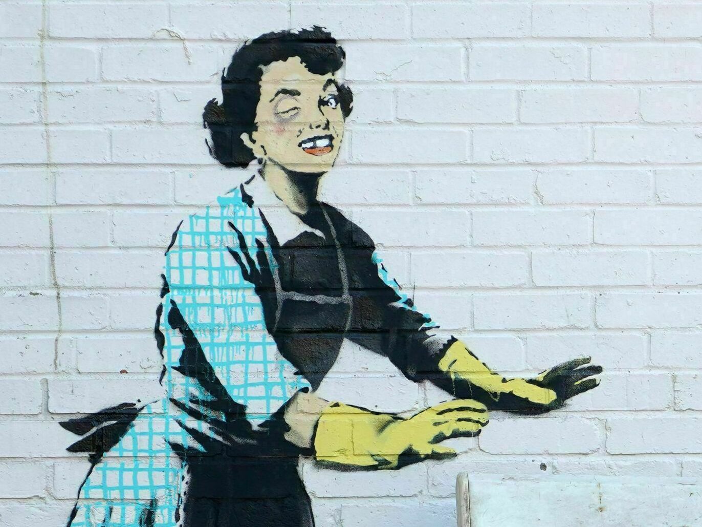 caption: <em>Valentine's Mascara</em> by street artist Banksy, on the side of a house in Margate, England.