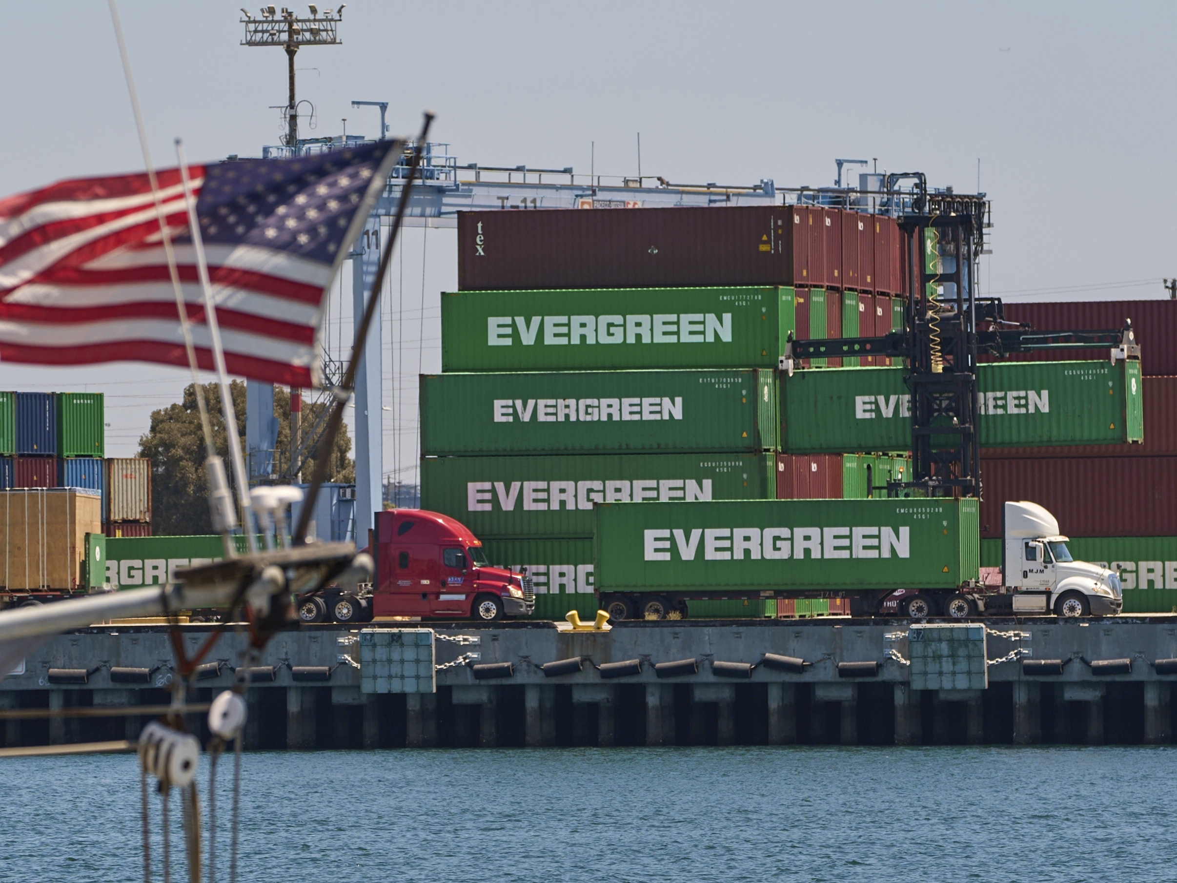 caption: Shipping containers sit stacked at the Evergreen terminal at the port of Los Angeles, Friday, Aug. 1, 2025.