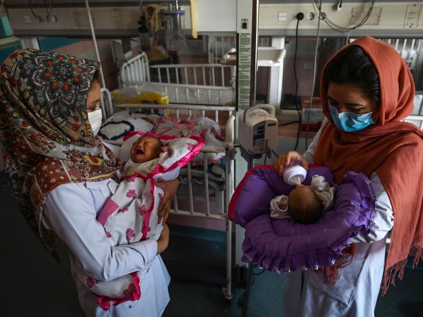 caption: Nurses feed newborn babies rescued and brought to Ataturk National Children's Hospital in Kabul, Afghanistan, on May 15, 2020, after their mothers were killed in an attack on a maternity ward operated by Doctors Without Borders. The health-care nonprofit runs clinics and hospitals in various parts of the country.