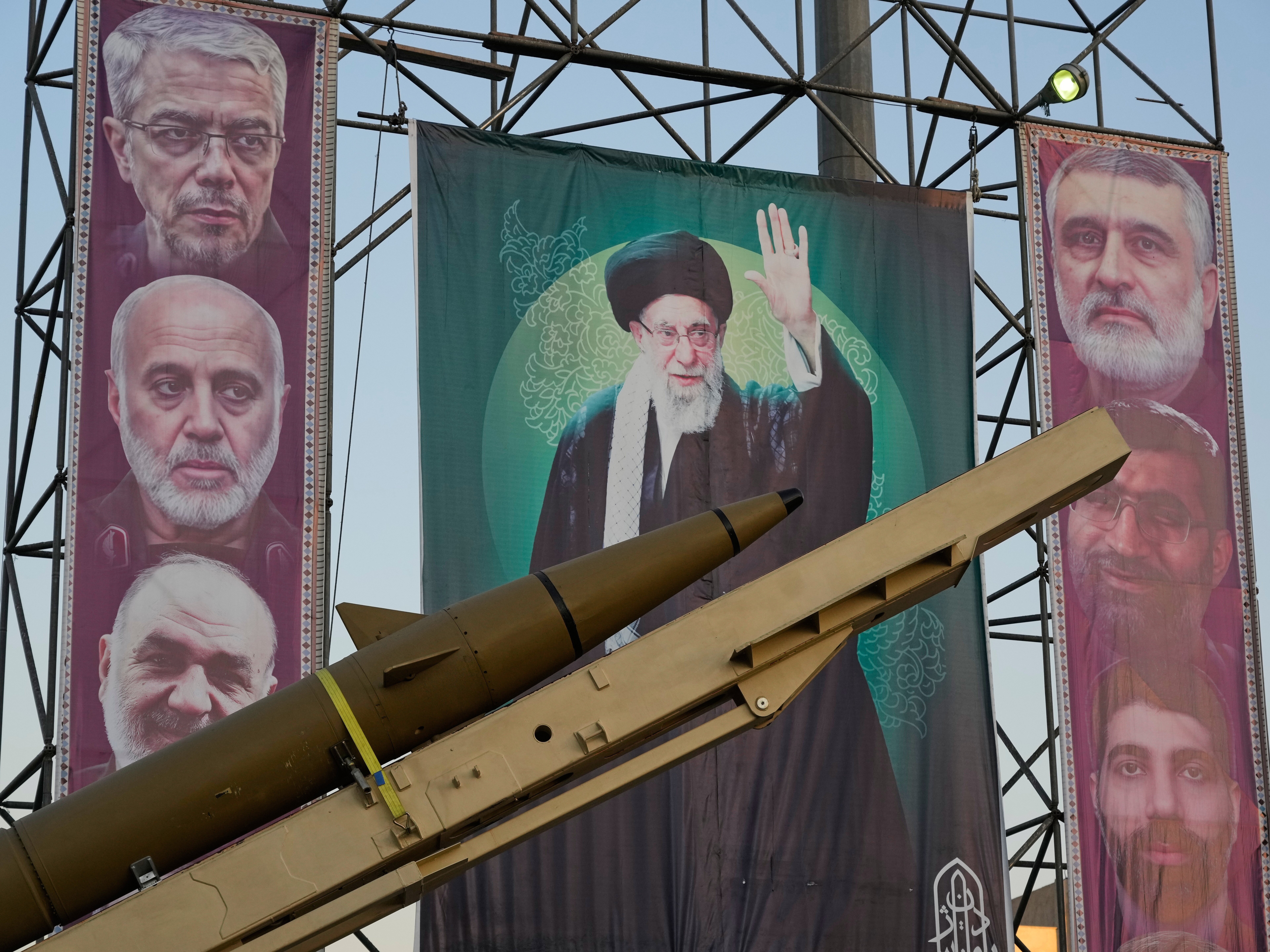 caption: A domestically-built missile and banners showing portraits of the Iranian Supreme Leader Ayatollah Ali Khamenei, center, and armed forces commanders who were killed in an Israeli strike in June, are displayed in Baharestan Square, Tehran, Thursday, Sept. 25, 2025.