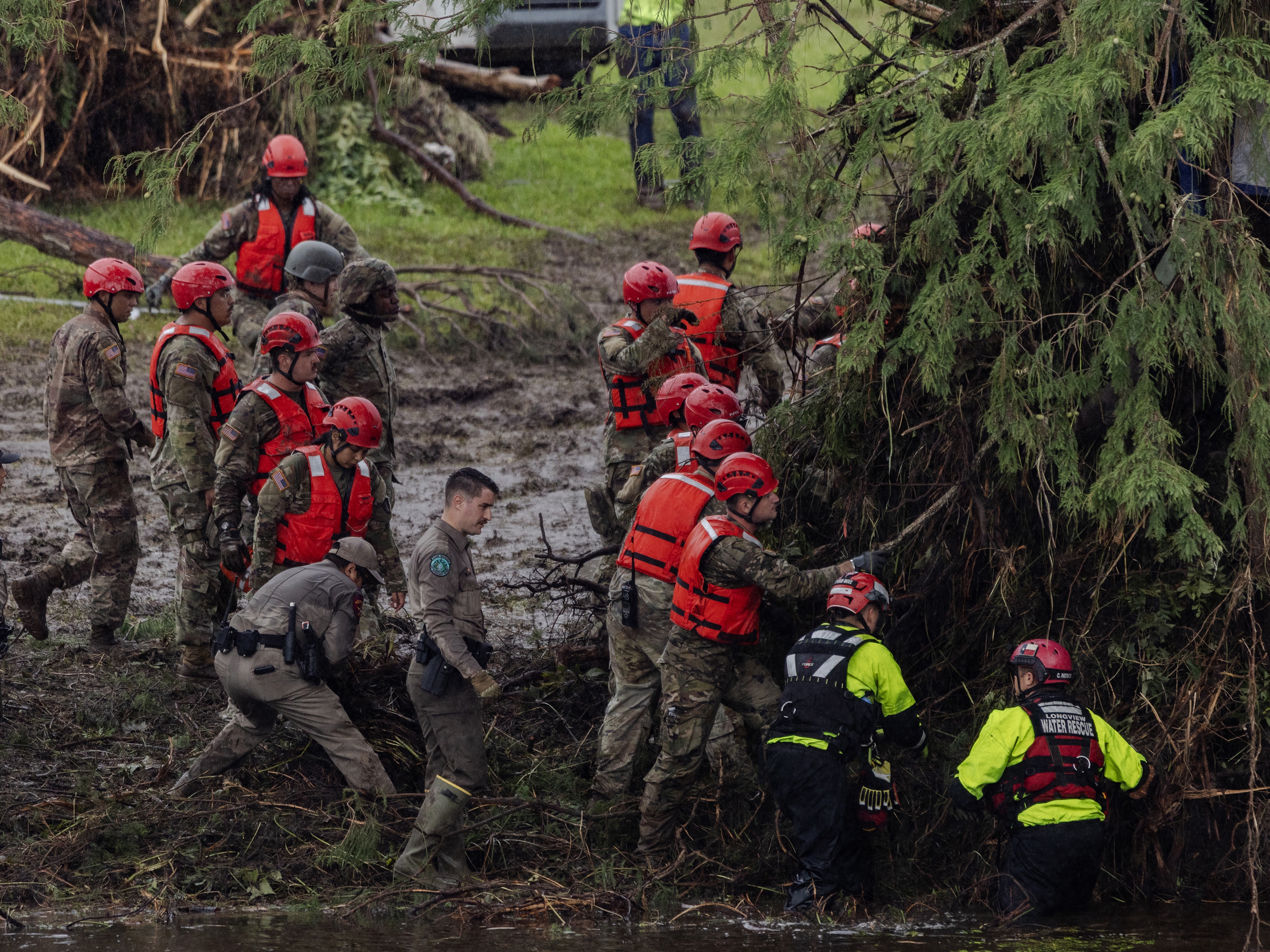 caption: Search and recovery workers dig through debris at Camp Mystic near Hunt, Texas, on Sunday.