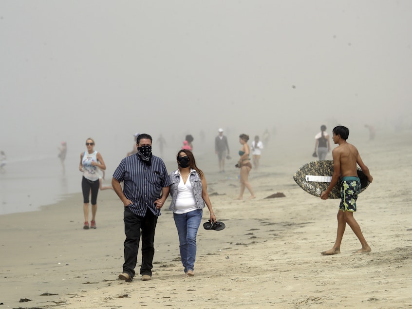 caption: Beachgoers flocked to Orange County seashores on Sunday, as pictured here in Huntington Beach. An order announced Thursday, by California Gov. Gavin Newsom will prohibit people from visiting any beaches or state parks in Orange County.