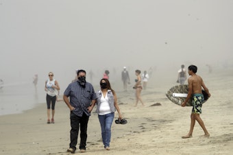 caption: Beachgoers flocked to Orange County seashores on Sunday, as pictured here in Huntington Beach. An order announced Thursday, by California Gov. Gavin Newsom will prohibit people from visiting any beaches or state parks in Orange County.