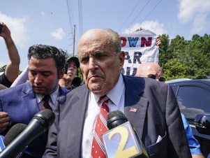 caption: Rudy Giuliani speaks outside the Fulton County jail in Atlanta on Aug. 23, before he surrendered on 13 felony charges related to efforts to try to overturn the 2020 election.