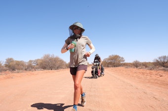 caption: Katie Visco running on the outskirts of the Simpson Desert in Australia. 