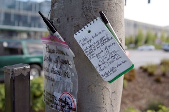 caption: At a makeshift memorial on Mercer Street, construction workers remember coworkers killed when a crane collapsed on Saturday, April 27 in Seattle's South Lake Union neighborhood.
