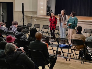 caption: Haben Haileslassie (left) stands next to Diana Muuru (center) and Mikayla Weary (right) at Washington Hall in Seattle's Central District. They are part of the Black Coffee Northwest Grounded youth program, and moderated a youth panel on public safety on Tuesday, Dec. 12, 2023.