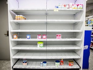 caption: Shelves normally meant for baby formula sit nearly empty at a store in downtown Washington, D.C., on May 22.