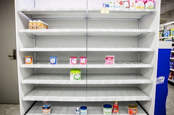 caption: Shelves normally meant for baby formula sit nearly empty at a store in downtown Washington, D.C., on May 22.