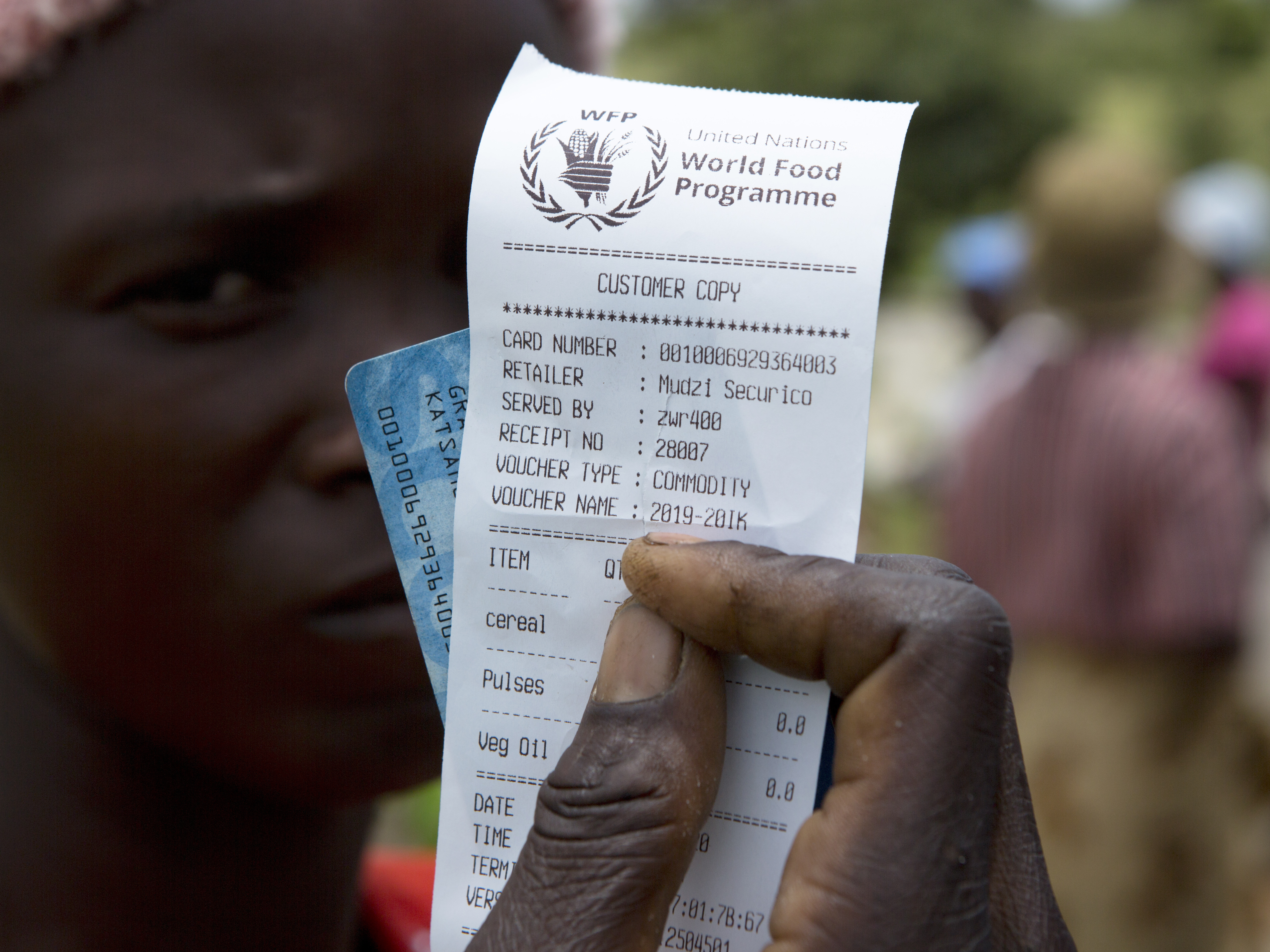 caption: A woman holds a voucher before receiving food aid in Mudzi, Zimbabwe, in February. On Friday, the United Nations World Food Programme received the 2020 Nobel Peace Prize.